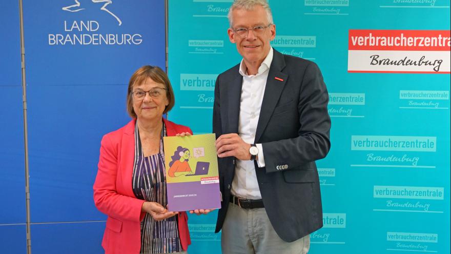 Christian A. Rumpke, Chef der Verbraucherzentrale Brandenburg, übergibt Verbraucherschutzministerin Ursula Nonnemacher den Jahresbericht 2023/24